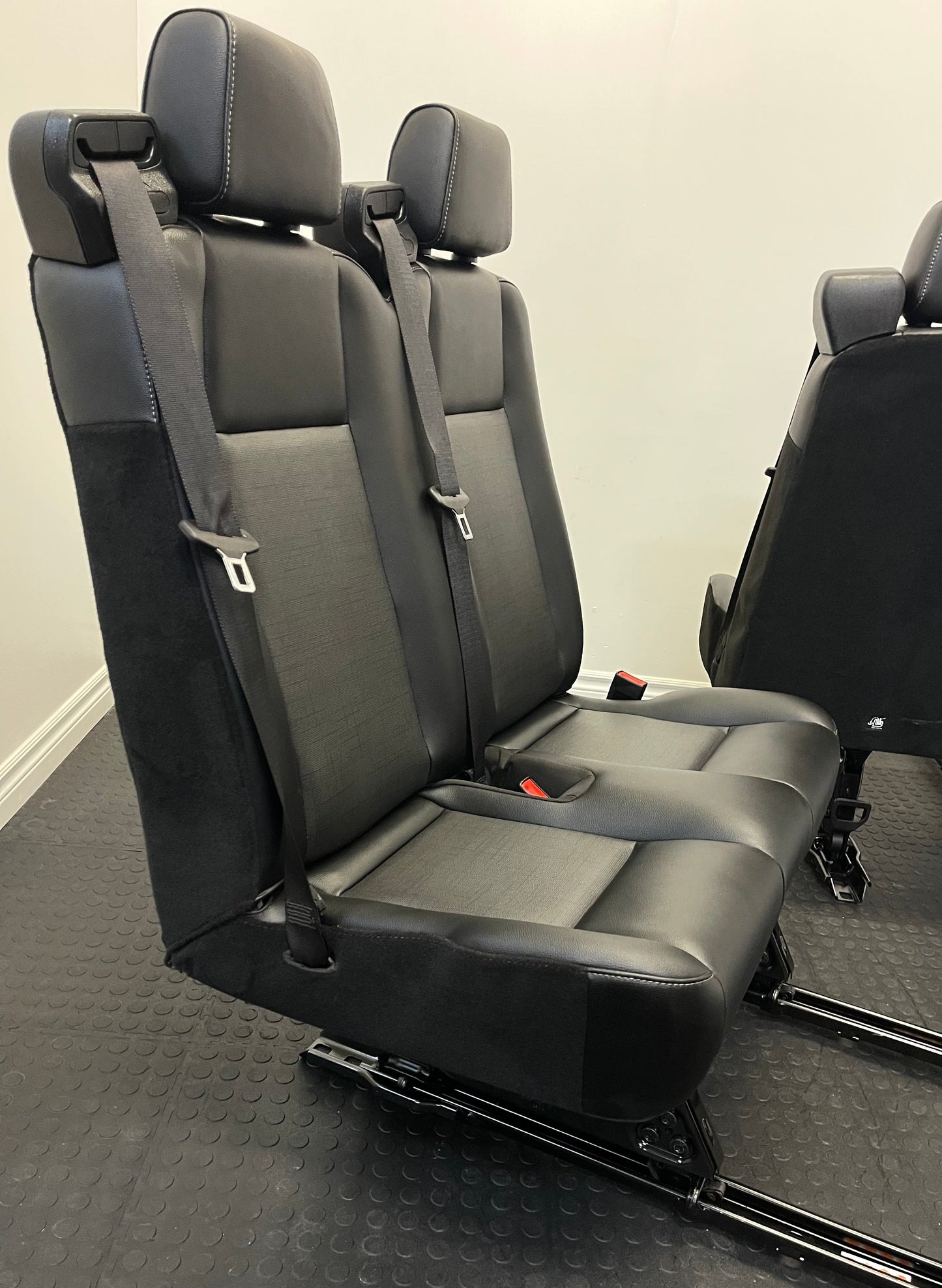 Ford Transit Passenger Van Black Vinyl Quick Release Universal Fit 4 Position Bench Seat 64” Wide Including the Seatbelt Retractor.