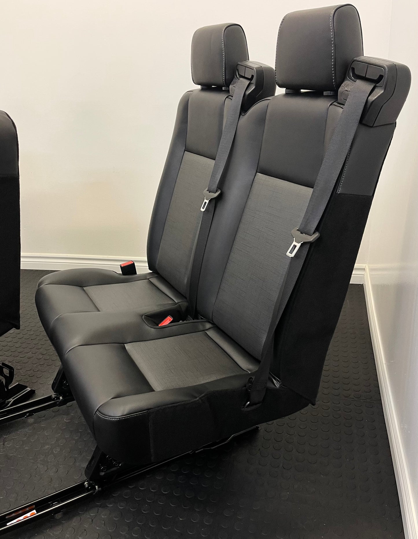 Ford Transit Passenger Van Black Vinyl Quick Release Universal Fit 4 Position Bench Seat 64” Wide Including the Seatbelt Retractor.