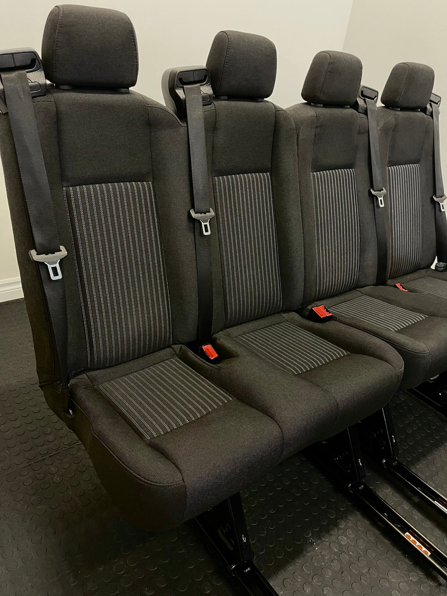 Ford Transit Passenger Van Black Cloth Quick Release Universal Fit 4 Position Bench Seat 64" Wide Including the Seatbelt Retractor.